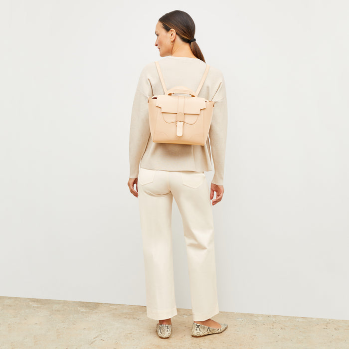 Image of a woman wearing the M.M.LaFleur x SENREVE Maestra Belt Bag in Chablis