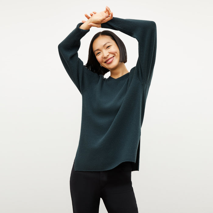 Front image of a woman wearing the ollie sweater in malachite