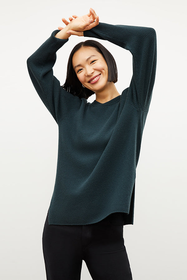 Front image of a woman wearing the ollie sweater in malachite | Exclude | Grid Hover