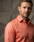 Man wearing a coral-colored shirt against a neutral background