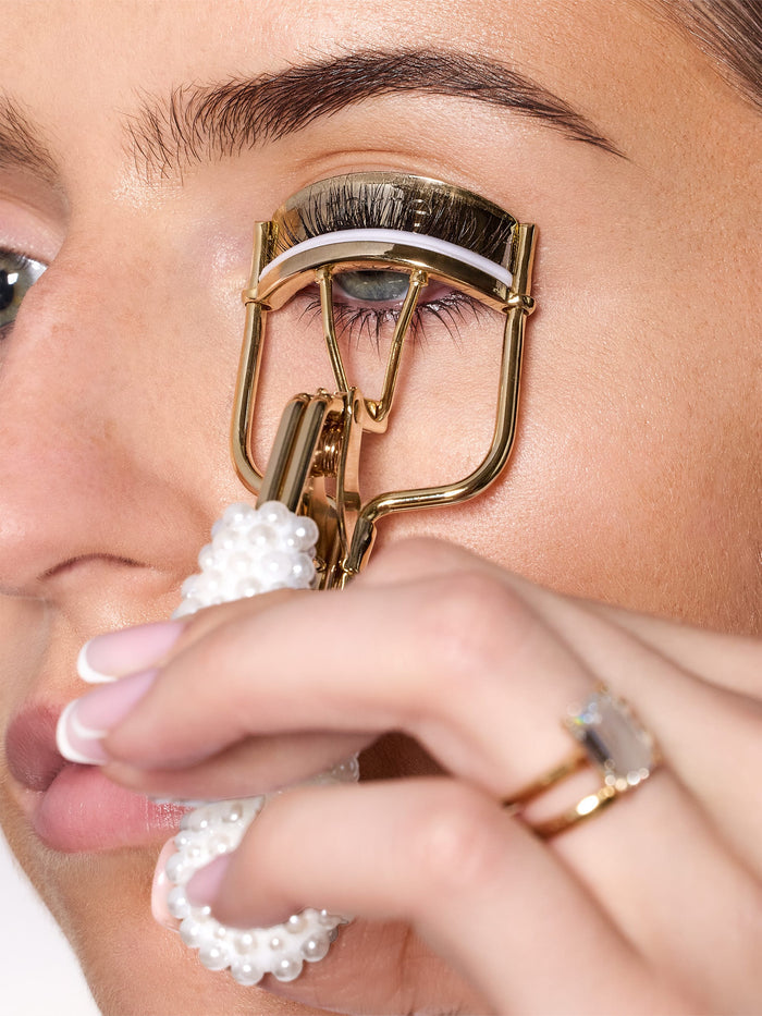 woman using tarte cosmetics pearl lash curler on her eyelashes