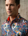 Man wearing a colorful, patterned shirt against a neutral background