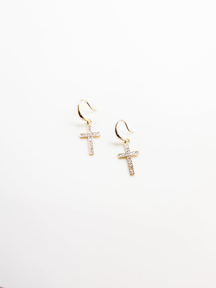 A pair of gold-tone sparkly cross earrings with crystal embellishments on a white background