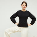 Front image of a woman standing wearing the rashida top in black | Lead