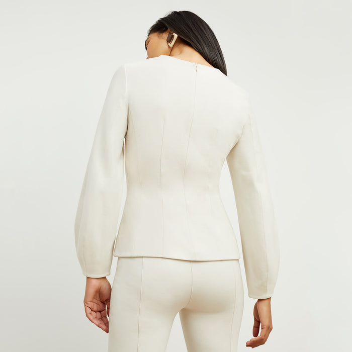 Back image of a woman standing wearing the rashida top in pearl