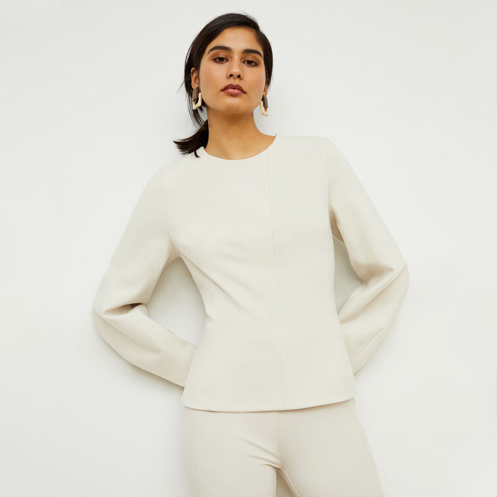 Front image of a woman standing wearing the rashida top in pearl