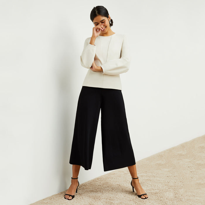 Front image of a woman standing wearing the rashida top in pearl