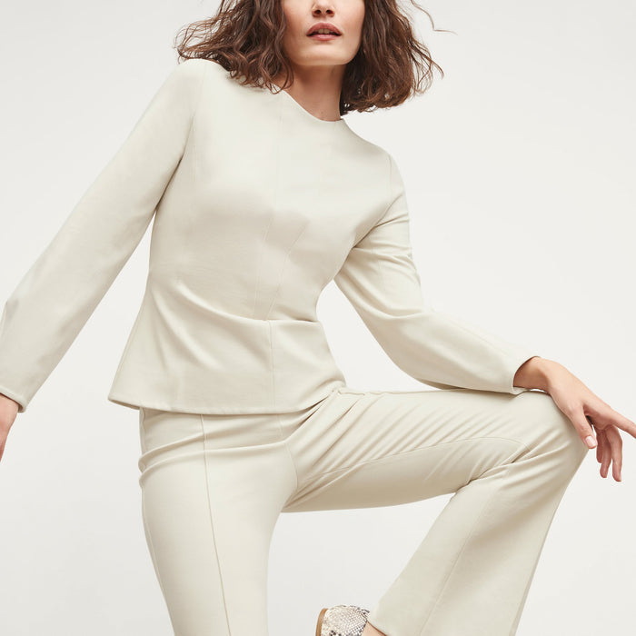 Front image of a woman standing wearing the rashida top in pearl