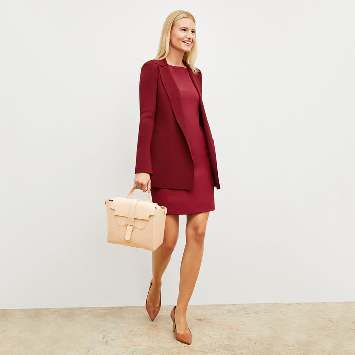Front image of a woman wearing the regina dress in cerise