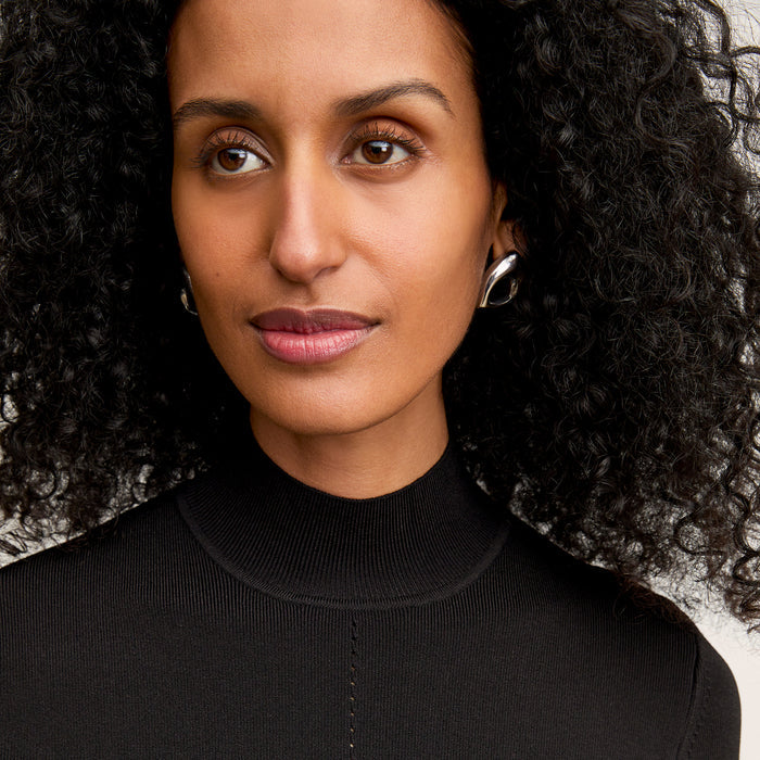 front image of a woman wearing the riya dress in black