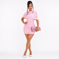 Pink ruched mini dress on model in front three-quarter pose with draped shoulder overlay and gathered body detail on white