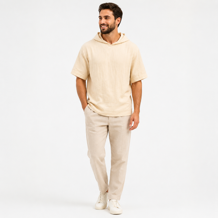 Man wearing an apricot short sleeve pullover hoodie, full-body front view on a white studio background.