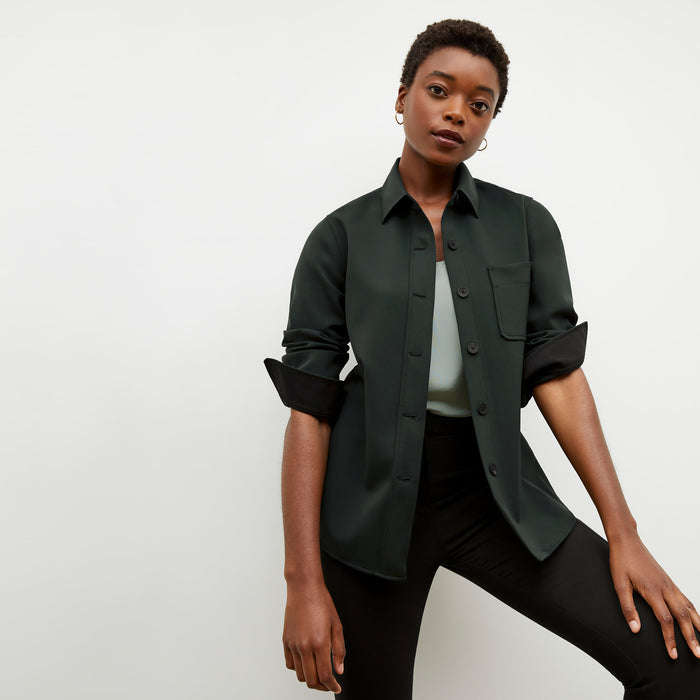 Front image of a woman wearing the sierra shacket in forest