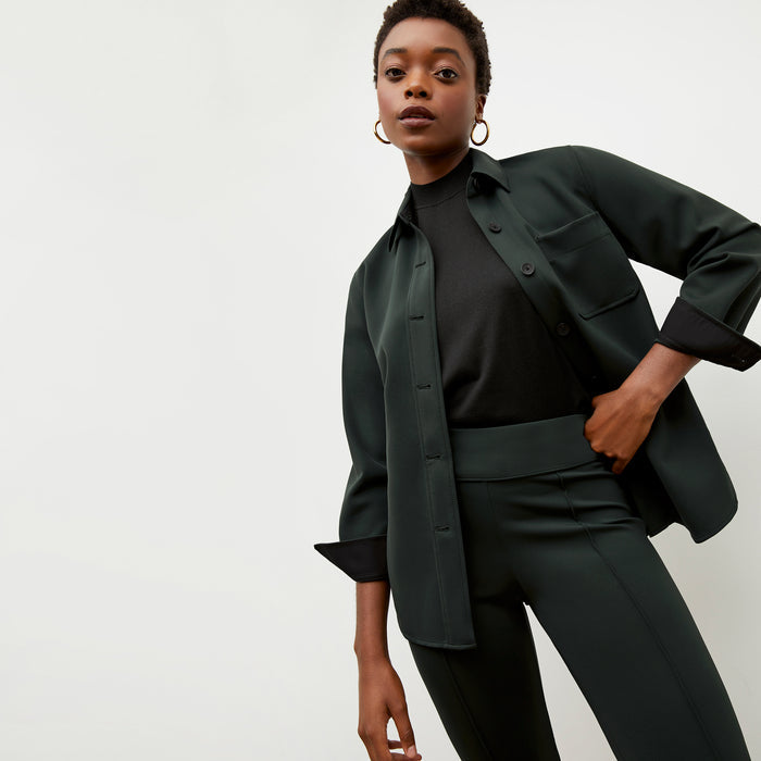 Front image of a woman wearing the sierra shacket in forest