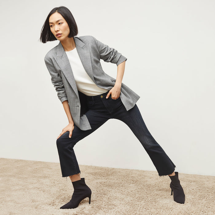 Front image of a woman standing wearing the FRAME Denim Le Crop Slim Bootcut Raw Edge Jean in Marcella