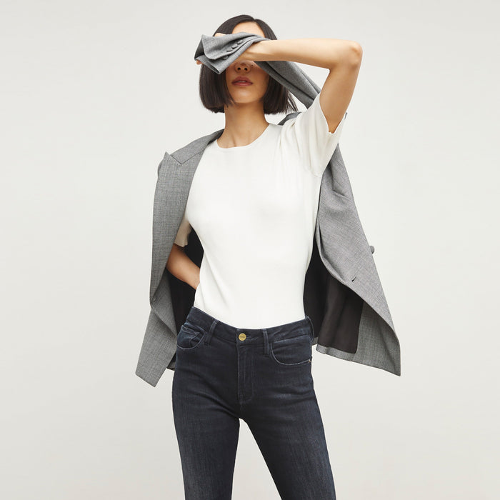 Detail image of a woman standing wearing the FRAME Denim Le Crop Slim Bootcut Raw Edge Jean in Marcella