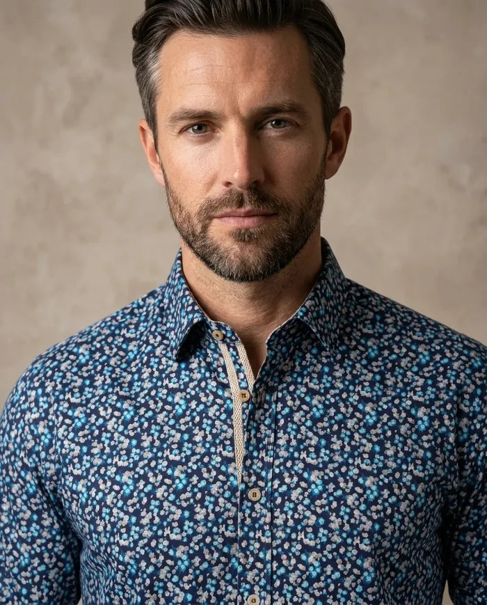 Man wearing a blue patterned shirt against a beige background