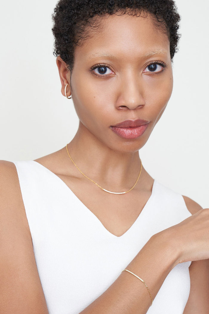 Front image of a woman standing wearing the Thread Bracelet in Yellow Gold | Grid Hover | Exclude
