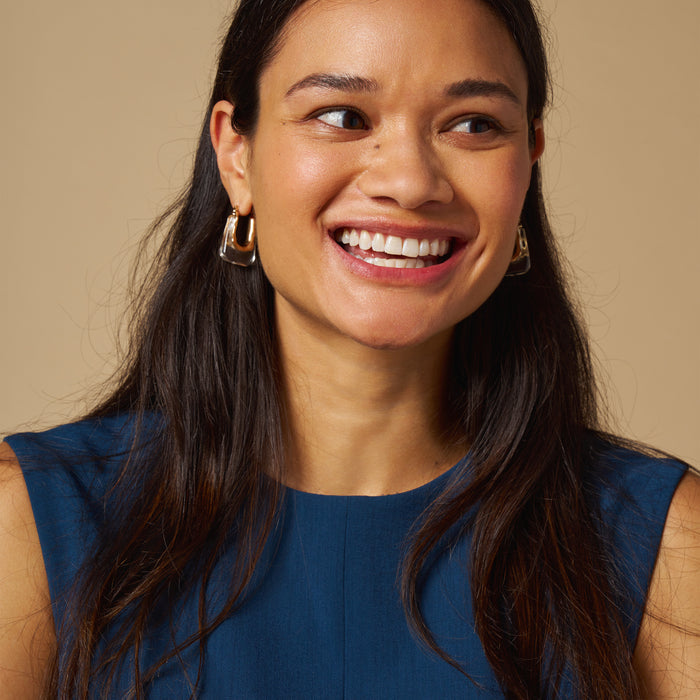 mood image of a woman wearing the toi dress in deep teal