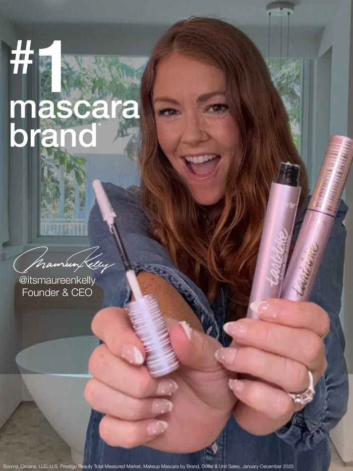 Woman applying mascara with a product labeled 'removes tubing mascara with just warm water'.