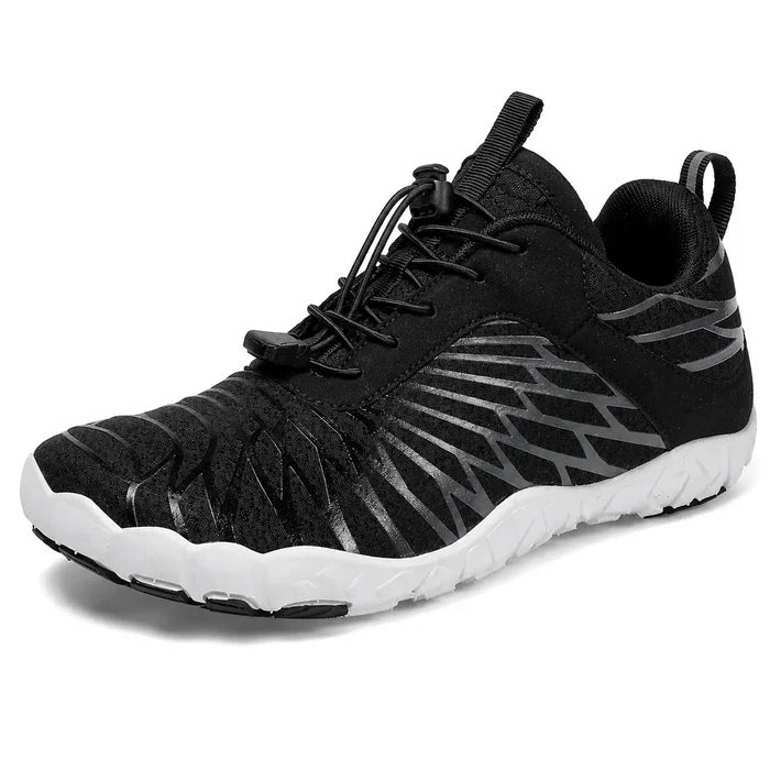 Black unisex slip-on hiking shoe close-up showing the mesh upper, elastic lace structure and low-cut profile detail on white.