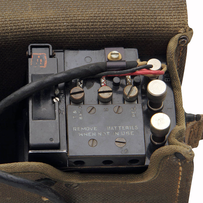 military surplus US Army Field Phone in canvas satchel uses two D-cell batteries and a connecting wire to function