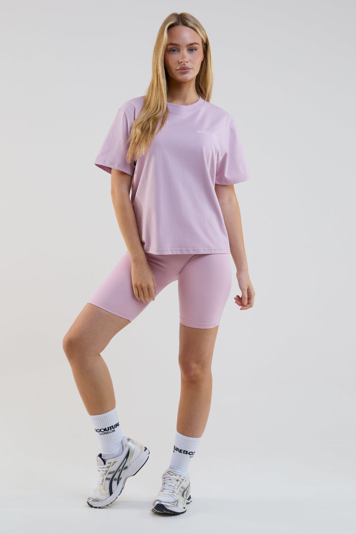 Woman wearing a light purple t-shirt and shorts set on a white background
