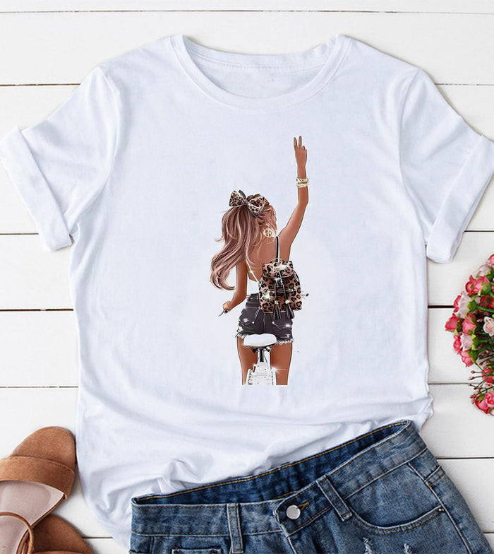 White short sleeve graphic tee featuring a centered fashion girl bicycle illustration with a leopard bow and matching accessory details.
