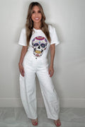 White wide leg jeans with allover rhinestone stud embellishment, button waist closure, belt loops, and five-pocket styling.