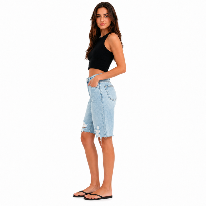 Women's high-waisted blue denim Bermuda shorts, side profile on a professional model