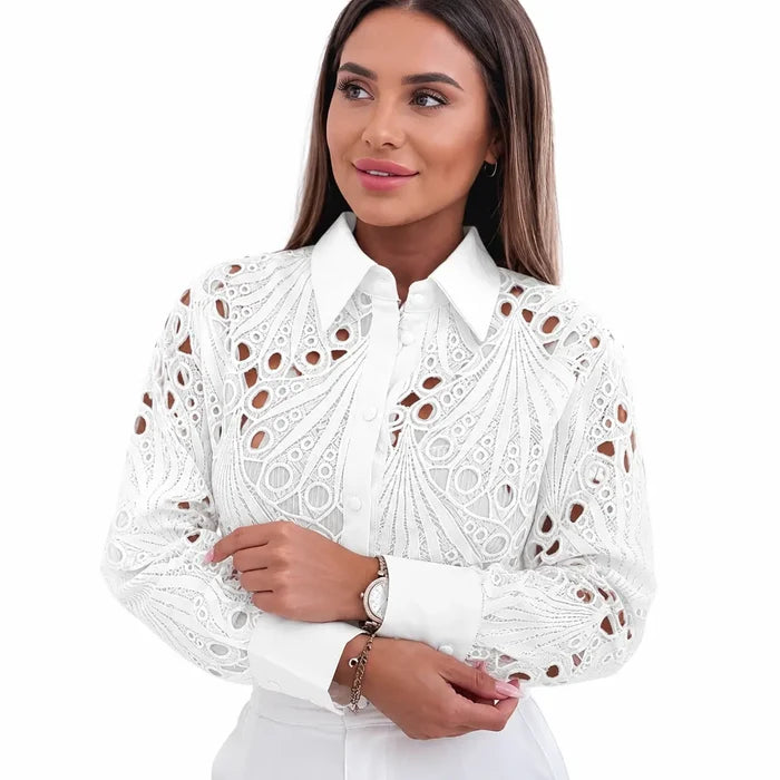 Close view of women's white lace hollow-out shirt showing the pointed collar, button front, long sleeves and wide cuffs well.