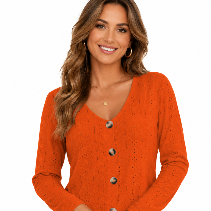 Close-up of women's orange V neck blouse showing button front and detailed eyelet texture on white studio background.