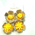 Orange and gold oversized flower statement earrings with textured metallic petals and a central beaded embellishment.